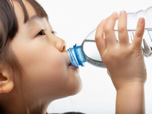 ペットボトルから水を飲む女の子