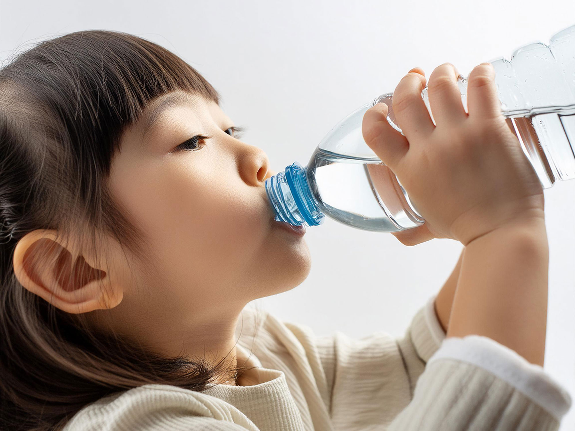 ペットボトルから水を飲む女の子