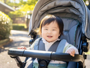 ベビーカーに乗って笑うかわいい赤ちゃん