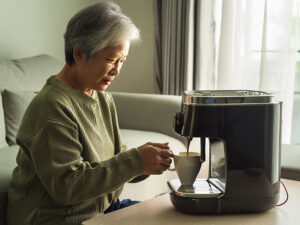 エスプレッソマシンでコーヒーを淹れるシニア女性