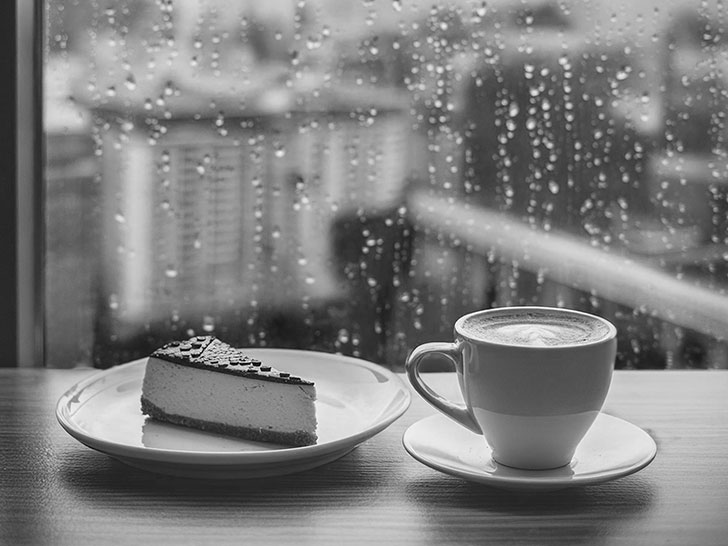 雨のカフェのホットコーヒーとケーキ