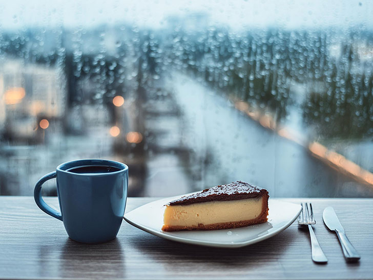 雨のカフェのホットコーヒーとケーキ