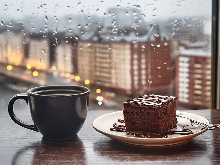 雨のカフェのホットコーヒーとケーキ