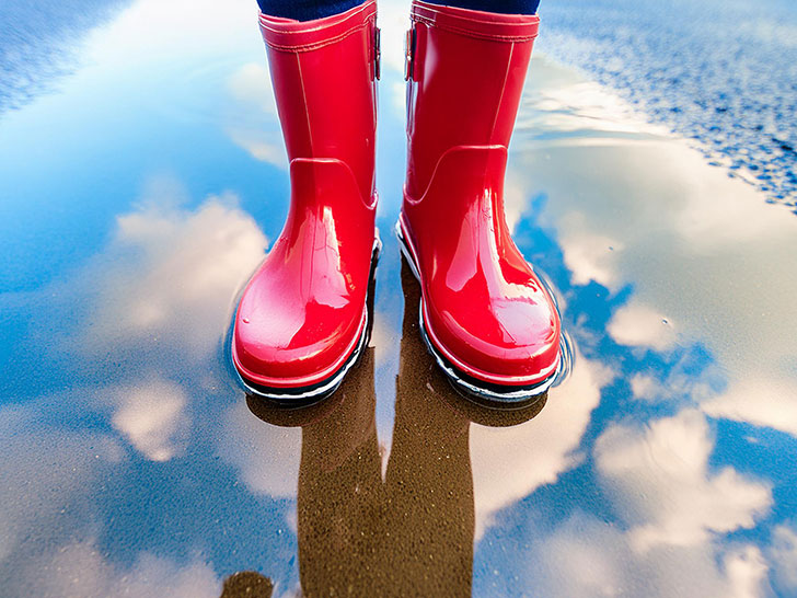 雨上がりの水たまりと赤い長靴