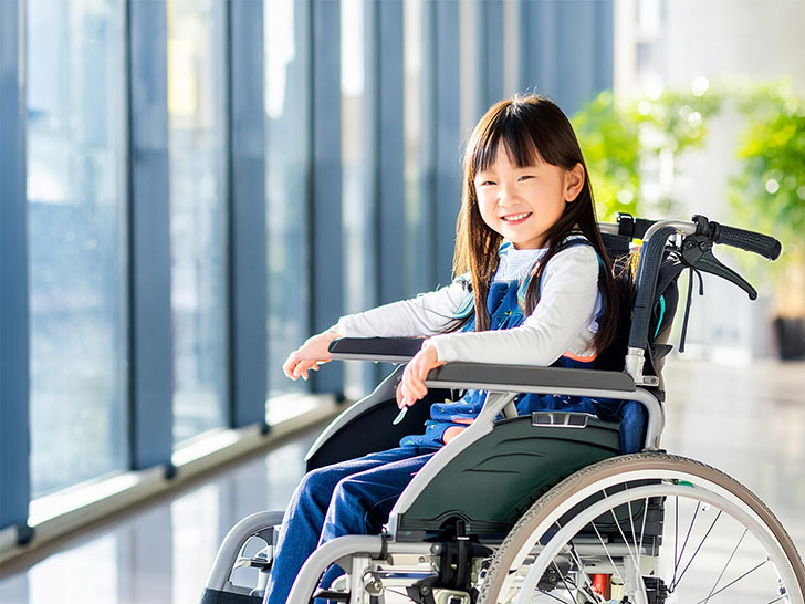 車いすで空港のロビーにいる小学生の女の子