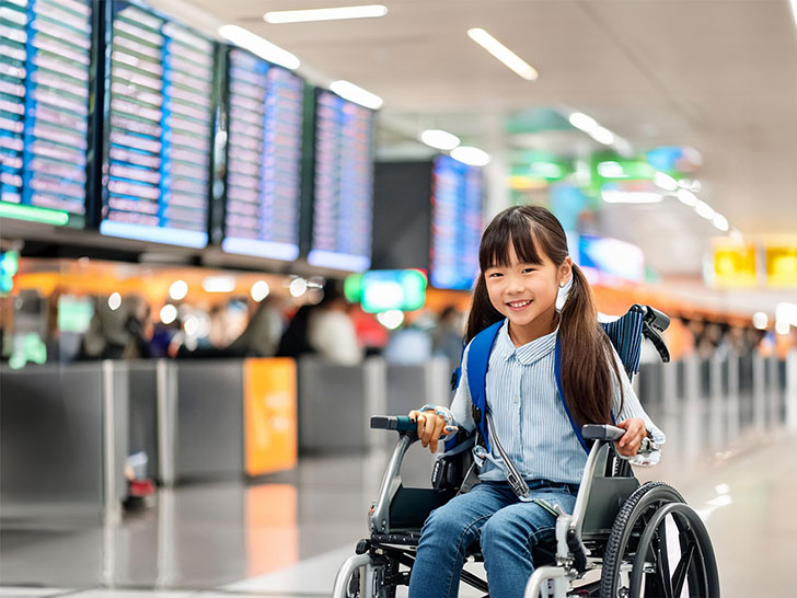 車いすで空港のロビーにいる小学生の女の子