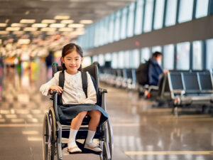 車いすで空港のロビーにいる小学生の女の子