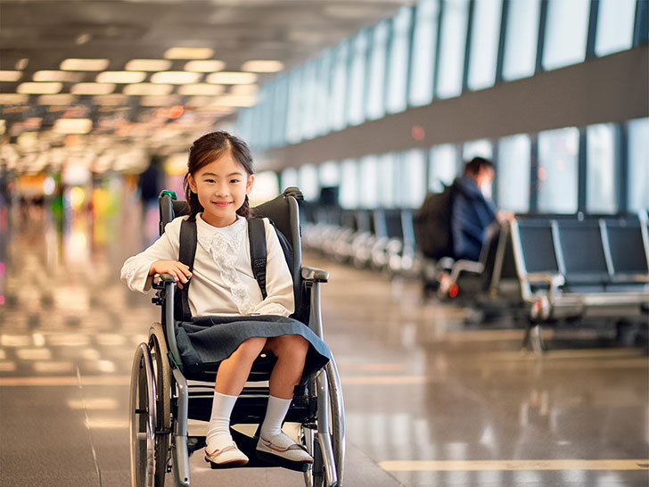 車いすで空港のロビーにいる小学生の女の子