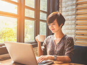 おしゃれなカフェでテレワークをする若い女性