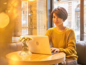 おしゃれなカフェでテレワークをする若い女性