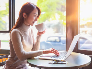 おしゃれなカフェでテレワークをする若い女性