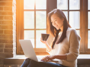 おしゃれなカフェでテレワークをする若い女性