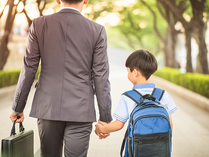 スーツを着て息子と手をつなぐ父親の後ろ姿