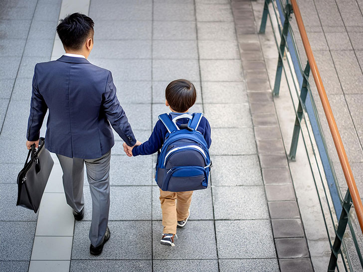 スーツを着て息子と手をつなぐ父親の後ろ姿