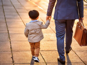 スーツを着て息子と手をつなぐ父親の後ろ姿