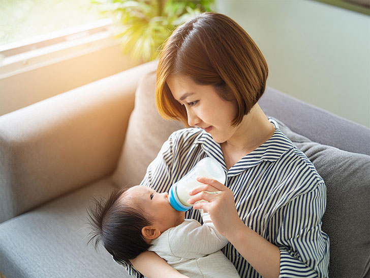 赤ちゃんにミルクをあげるお母さん