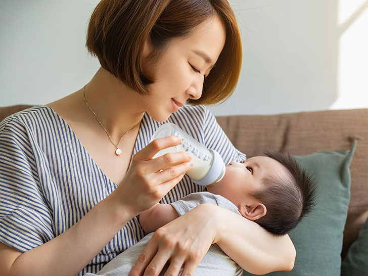 赤ちゃんにミルクをあげるお母さん