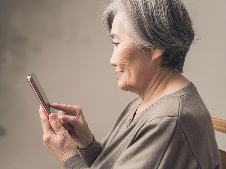 スマホを操作する高齢女性