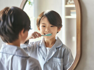 鏡の前で歯磨きをする小学生の男の子