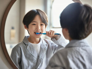 鏡の前で歯磨きをする小学生の男の子