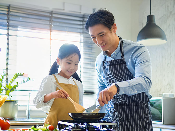 一緒に料理をするお父さんと小さな女の子