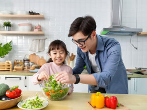 一緒に料理をするお父さんと小さな女の子