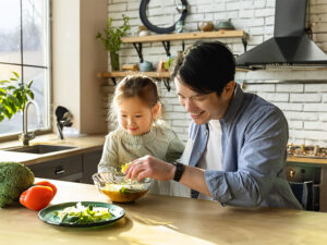 一緒に料理をするお父さんと小さな女の子