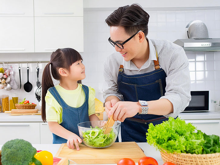 一緒に料理をするお父さんと小さな女の子