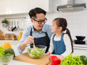 一緒に料理をするお父さんと小さな女の子