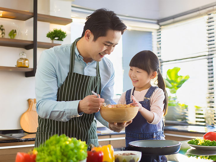 一緒に料理をするお父さんと小さな女の子