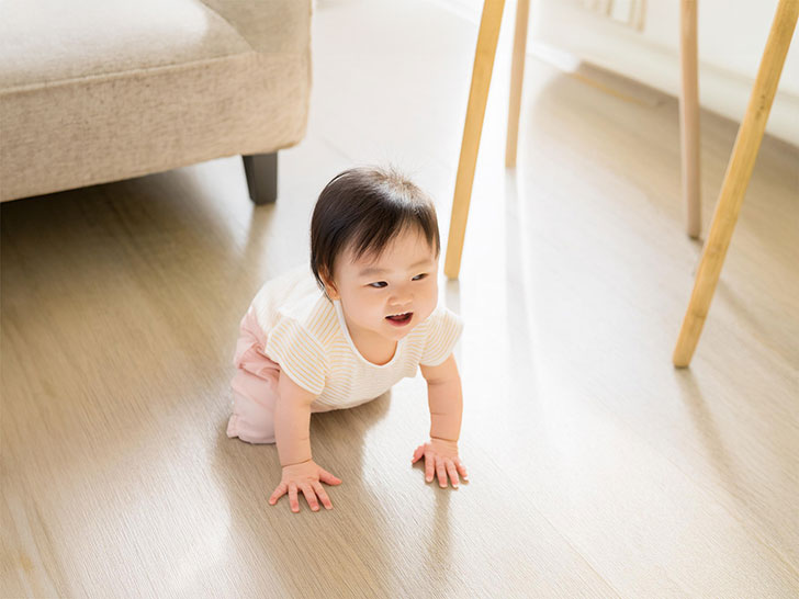 明るいリビングでハイハイするかわいい赤ちゃん