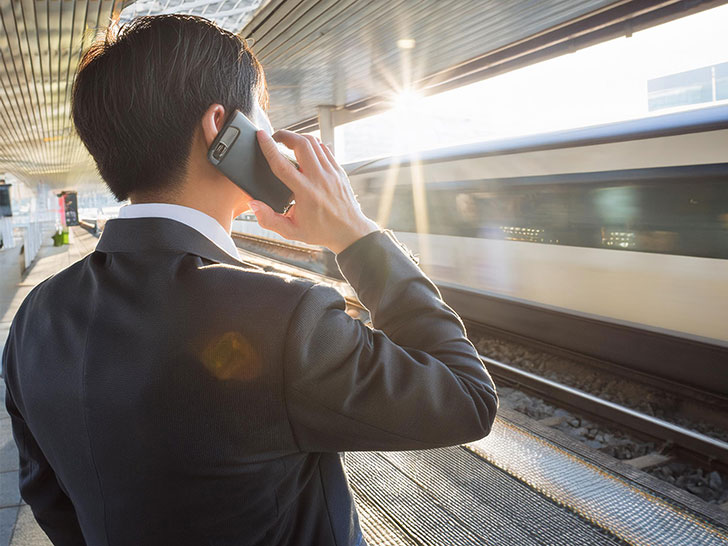 スマホで話す若いビジネスマンの後ろ姿