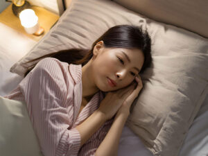 ベッドに横たわって眠れずにいる若い女性