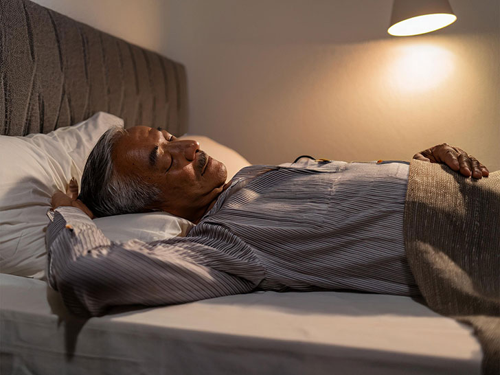 ベッドで眠るシニア男性