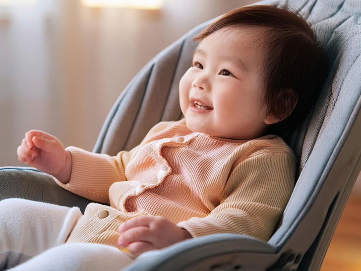 椅子に座って笑うかわいい赤ちゃん