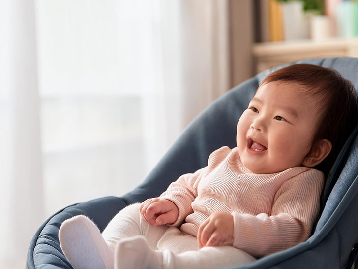 椅子に座って笑うかわいい赤ちゃん