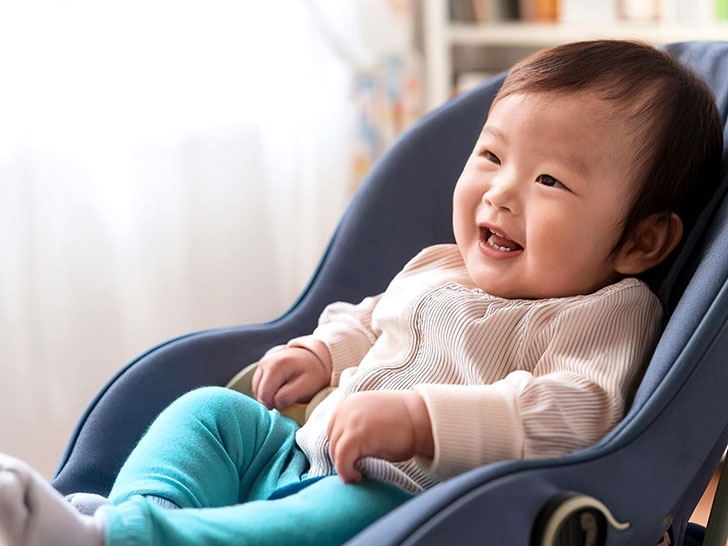 椅子に座って笑うかわいい赤ちゃん