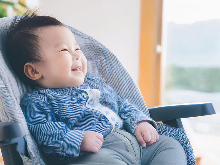 椅子に座って笑うかわいい赤ちゃん