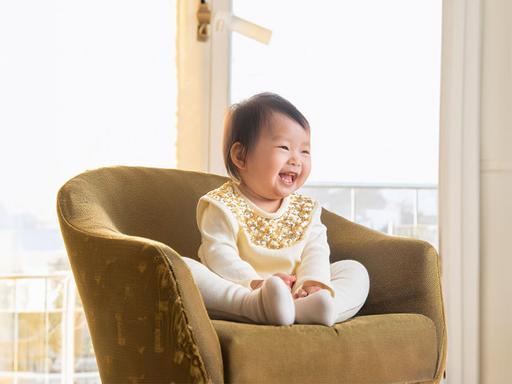 椅子に座って笑うかわいい赤ちゃん