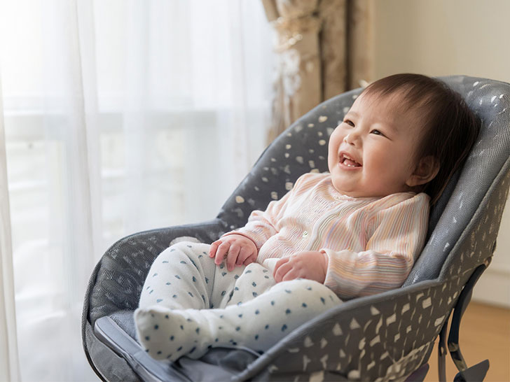 椅子に座って笑うかわいい赤ちゃん