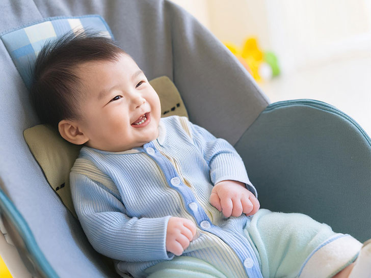 椅子に座って笑うかわいい赤ちゃん