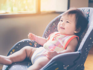 椅子に座って笑うかわいい赤ちゃん