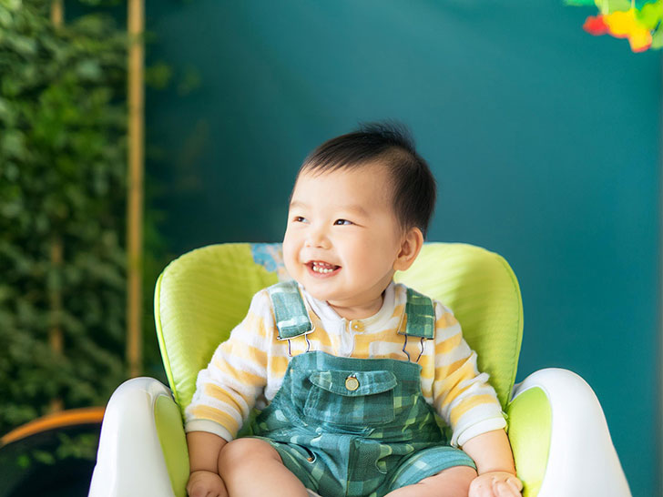 椅子に座って笑うかわいい赤ちゃん