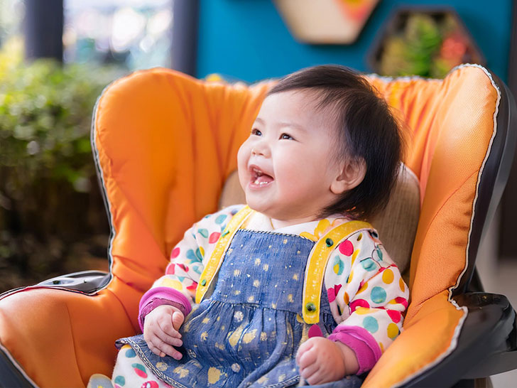 椅子に座って笑うかわいい赤ちゃん