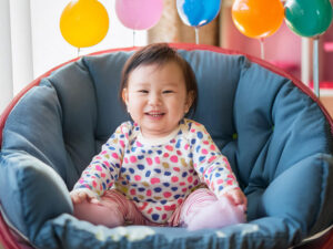 椅子に座って笑うかわいい赤ちゃん