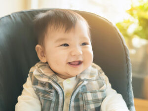 椅子に座って笑うかわいい赤ちゃん