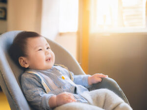 椅子に座って笑うかわいい赤ちゃん