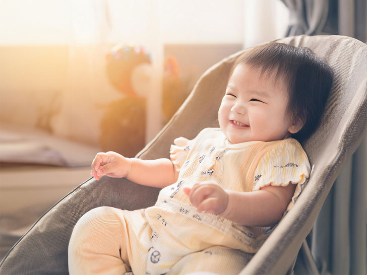 椅子に座って笑うかわいい赤ちゃん