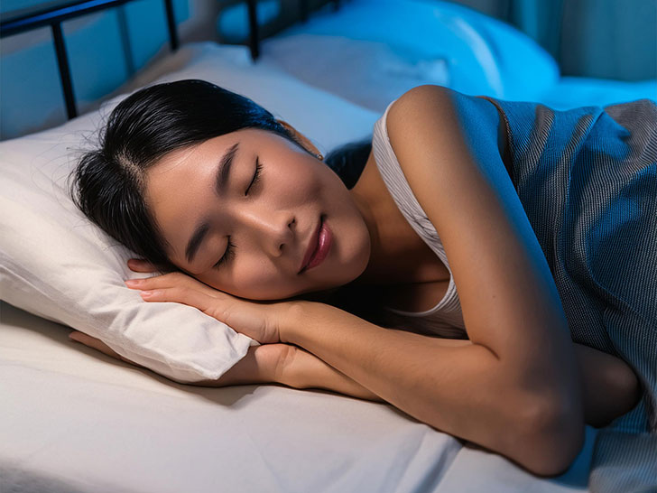 ベッドで眠る若い女性