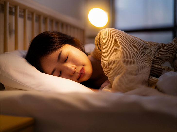 ベッドで眠る若い女性